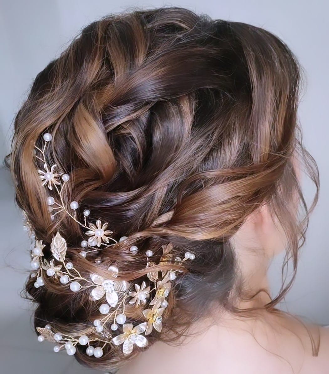 Chignon flou tressé avec vigne de fleurs et perles dorées, réalisé à Lannion