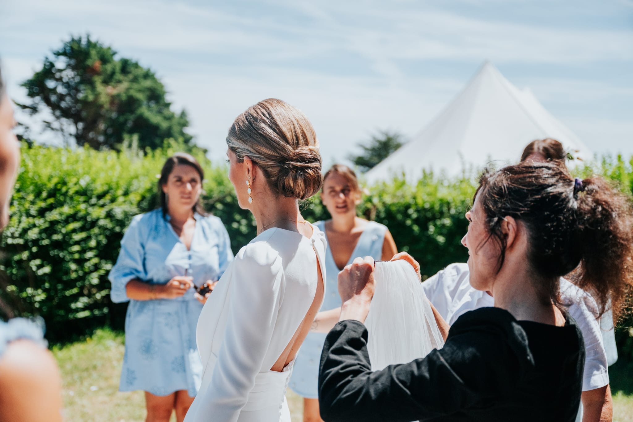 Pose du voile sur le chignon bas de la mariée, entourée de ses demoiselles d'honneur dans un jardin du Trégor