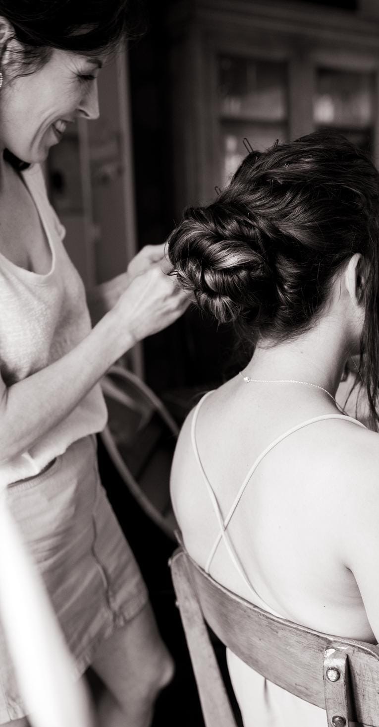 Réalisation d'un chignon tressé pendant les préparatifs, en noir et blanc
